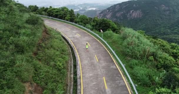 山岳道路を走るフィットネス女子ランナーの空中ビュー — ストック動画