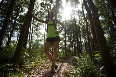 Genç bayan koşucu tropikal ormanda koşarken dinleniyor.