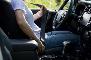 Kadın sürücü off road arabası sürmeden önce emniyet kemerini bağlar.