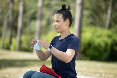 Şehirde yüz maskesi takan Asyalı bir kadın