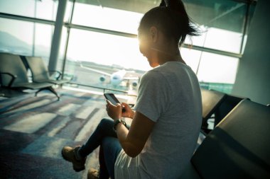 Havaalanında cep telefonu kullanan bir kadın.