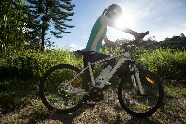 若い女性サイクリストは夏の森のトレイルで美しい日の出を楽しむ — ストック写真