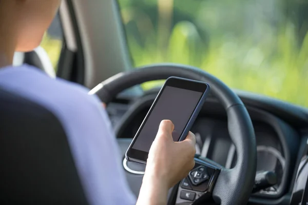 自然の中でオフロード車を運転しながらスマートフォンを使用して女性ドライバー — ストック写真