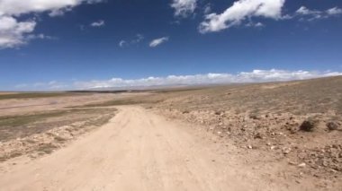 Dağlarda yüksek rakımlı tozlu yolda off-road araba sürmek