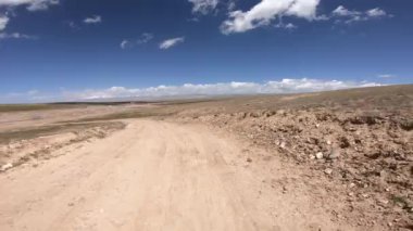 Dağlarda yüksek rakımlı tozlu yolda off-road araba sürmek