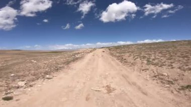 Dağlarda yüksek rakımlı tozlu yolda off-road araba sürmek