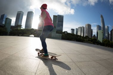 Modern şehirde Asyalı kaykaycı kadın.