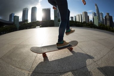 Modern şehirde Asyalı kaykaycı kadın.