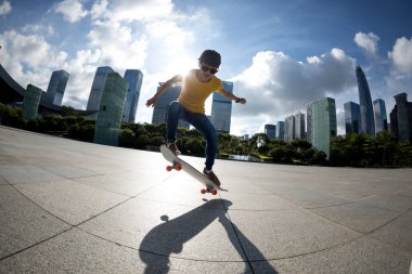 Modern şehirde Asyalı kaykaycı kadın.