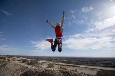 Kum tepelerinde atlayan başarılı bir kadın koşucu.
