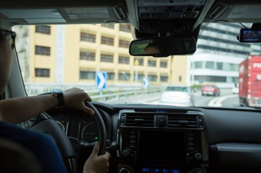 Şehir yolunda araba sürüyorum. Zebra geçidinin önünde bekliyorum.