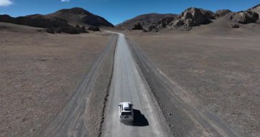 Yüksek irtifada göl kenarında çalışan off-road aracının hava görüntüleri.