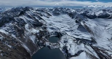 Hava görüntüleri, karla kaplı tepeleri ve gölleri olan nefes kesici bir dağ manzarası yakalıyor..