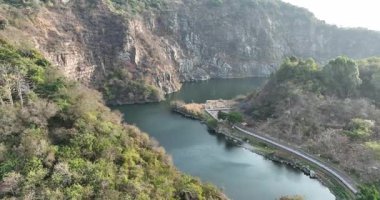 Dik, kayalık uçurumlar ve gür tepeler arasında büyük, sakin bir göl..