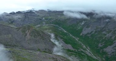 Dağların manzarasının ve bulutlu gökyüzünün havadan videosu 