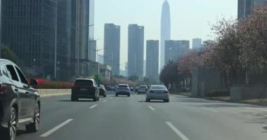 Arabalar geçerken modern binalar Çin 'in Shenzhen şehrinde bir yol çiziyor..