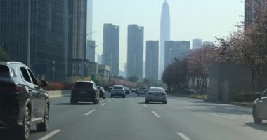 Arabalar geçerken modern binalar Çin 'in Shenzhen şehrinde bir yol çiziyor..