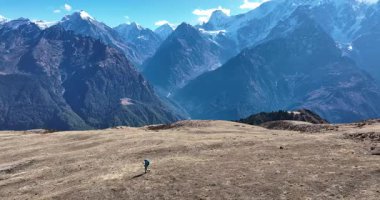Sırt çantalı bir kadının yüksek irtifada yürüyüş yaptığı kısa hava videosu. 