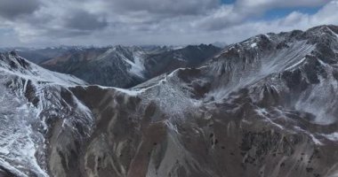 Çin, Tibet 'in sakin ve yükseltilmiş bölgesinde bulunan görkemli, karla kaplı dağlar.