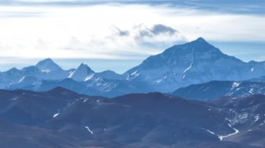 Issız ve düz bir arazide uzanan bir dağ sırası olan bir yolun videosu. Tibet, Çin