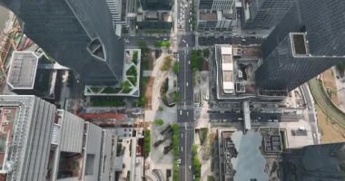 Shenzhen, Çin, Havacılık videosu yüksek binalarla çevrili bir şehir yolunda hareket eden arabaları yakalıyor  