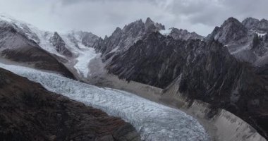 Geniş açılı bir video dağ vadisinden aşağı akan büyük bir buzulu gösteriyor..