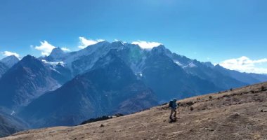 Karlı bir dağ sırasına doğru yürüyen bir yürüyüşçünün yavaş çekim videosu 