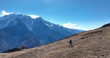 Karlı bir dağ sırasına doğru yürüyen bir yürüyüşçünün yavaş çekim videosu 