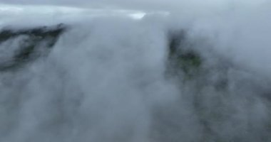 Bulutların arasından drone videosu, yeşil bitkilerle dağların manzarası 