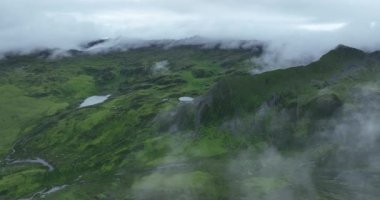 Dağ görüntülerinin hava aracı videosu. Yeşil bitkilerle kaplı manzara 