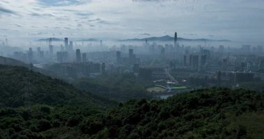 Şehir siluetinin geniş açılı drone görüntüsü kalın bir sis tarafından kısmen gizlenmiş..