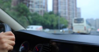 Hareket halindeki bir arabanın içinden şehrin sokak manzarasının bulanık videosu.