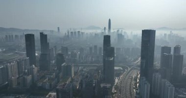 Şehir siluetinin geniş açılı drone görüntüsü kalın bir sis tarafından kısmen gizlenmiş..