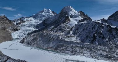 Uçsuz bucaksız, karla kaplı, birden fazla kayalık zirvesi ve buzulu olan bir dağ manzarasının görkemli manzarası..