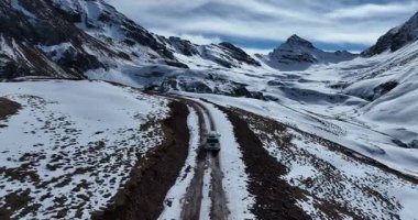 Karlı dağ yolunda araba sürüyor.