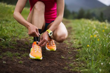 Yüksek rakımlı çayırlarda ayakkabı bağı bağlayan patika koşucusu.