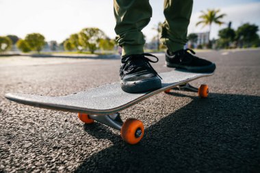 Kesilmiş görüntü. Otoparkta kaykaylı biri, sürmeye hazır. 