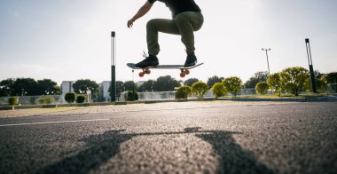 Kaykaylı bir insan bir numara yapar, otoparkta havaya atlamak..