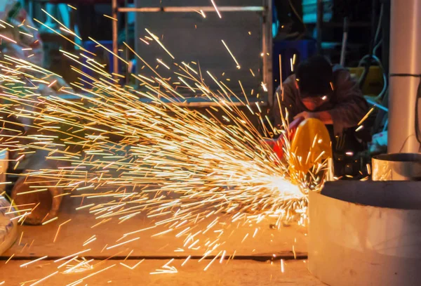 İnşaat alanında, kaynak işçiler işyerinde, fabrika çelik yapısı üzerinde taşlama elektrikli tekerlekli