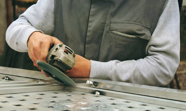 İnşaat alanında, kaynak işçiler işyerinde, fabrika çelik yapısı üzerinde taşlama elektrikli tekerlekli