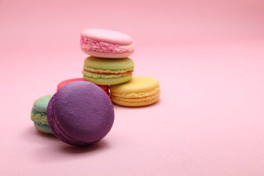 Renkli pasta macaron veya önden görünüm, renkli badem çerezler, pastel renkler, vintage kartı pembe arka plan üzerinde acıbadem kurabiyesi