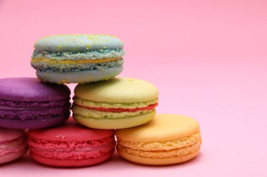 Renkli pasta macaron veya önden görünüm, renkli badem çerezler, pastel renkler, vintage kartı pembe arka plan üzerinde acıbadem kurabiyesi