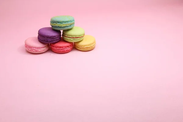 Colorful cake macaron or macaroon on pink background from front view, colorful almond cookies, pastel colors, vintage card