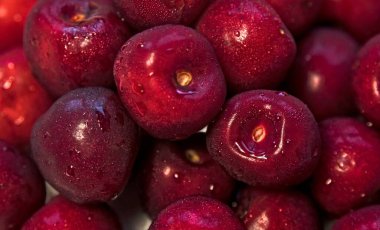 Yüzeyde çok fazla vişne var. Bir sürü kırmızı, bordo, lezzetli, sağlıklı, iştah açıcı, ıslak yüzey kirazları, bütün yıl boyunca yenebilir..