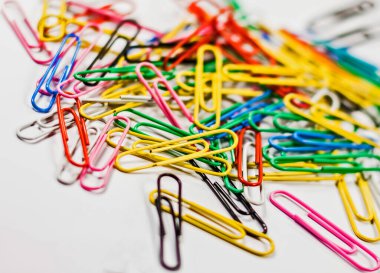 Birçok renkli, kırmızı, sarı, mavi, yeşil, siyah, beyaz, pembe ataçlar beyaz arkaplan üzerine yerleştirilmiş..