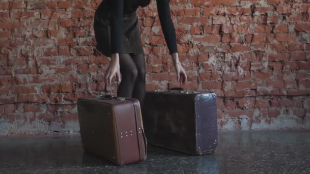 赤いレンガの背景に赤いレンガを背景にスーツケースを手にした少女 — ストック動画