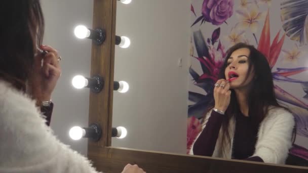 女孩模型看起来要化妆化妆梳上她的头发染她的嘴唇 — 图库视频影像