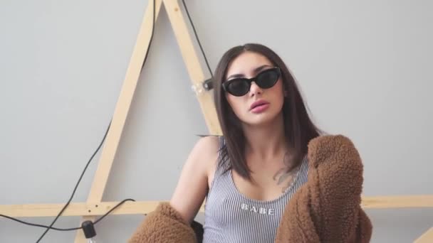 Menina Divertindo Cama Com Casaco Pele Óculos Pretos Maiô — Vídeo de Stock