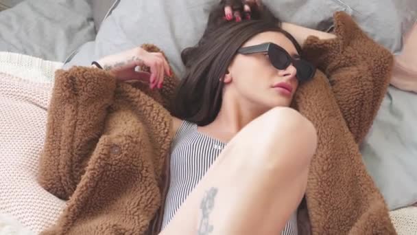 Chica Divirtiéndose Cama Abrigo Piel Gafas Negras Traje Baño — Vídeos de Stock