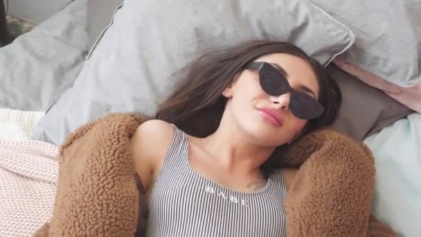Menina Divertindo Cama Com Casaco Pele Óculos Pretos Maiô — Vídeo de Stock